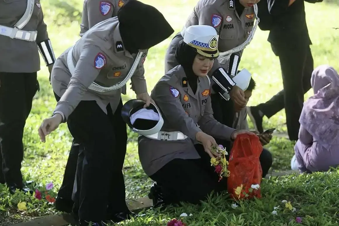 aceh-police-distribute-flowers-to-visitors-at-mass-tsunami-gravesite