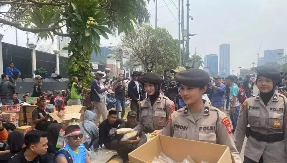 metro-jaya-female-police-officers-distribute-meals-to-protesters-outside-dpr-building